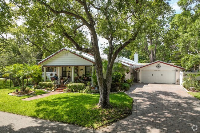 A beautiful little bungalow sits in the shade and lush landscaping in Palmetto Beach.