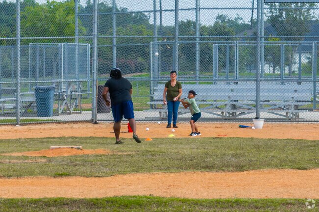 Families practice baseball together at Lions Ball Park near Manvel.