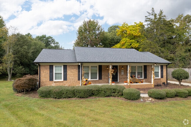 A ranch style home with a large porch and fall decorations in Wendover Place.