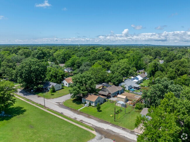 Aerial view of a peaceful neighborhood surrounded by trees in Pryor Creek.