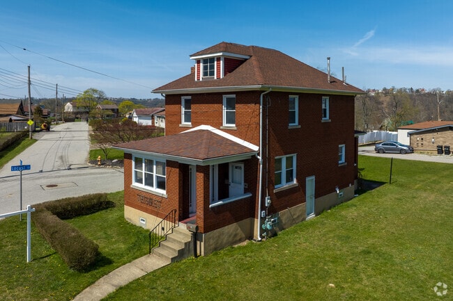 A red brick American four square home with large lawn in the Liberty neighborhood.