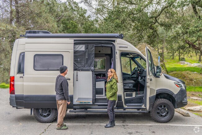 A couple enjoys the tranquility in Mt. Diablo State Park outside their camper van.