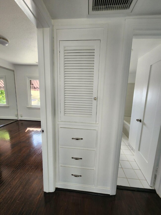 Hallway view of second bedroom, linen storage, and bathroom
