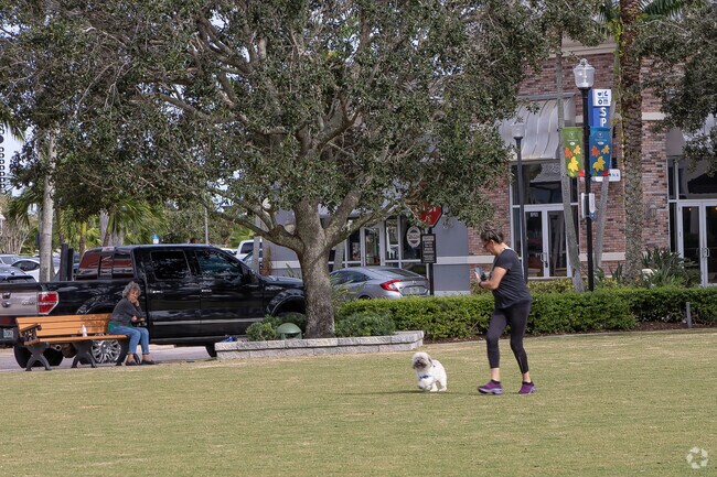 Woman enjoys play time with her fur baby in the green space at Tradiation.