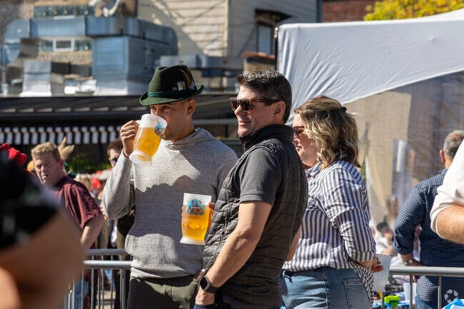 Friends yell "Prost" as they sip a pint of imported German beer at Lincoln Squares Oktober Fest.