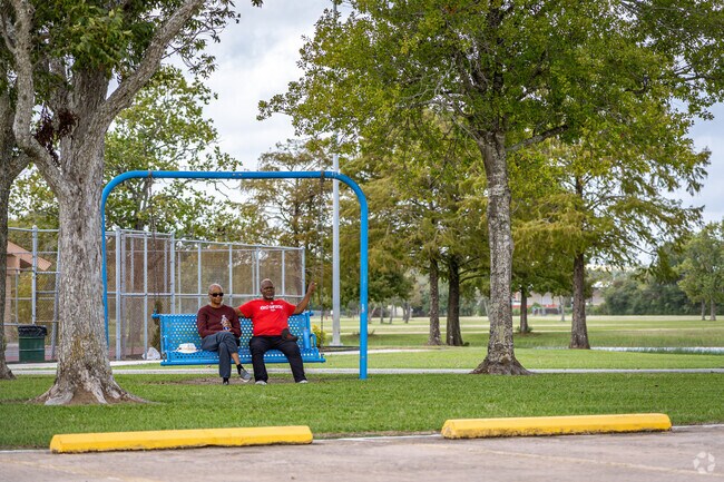 The residents are having a good time on the swings at the park.