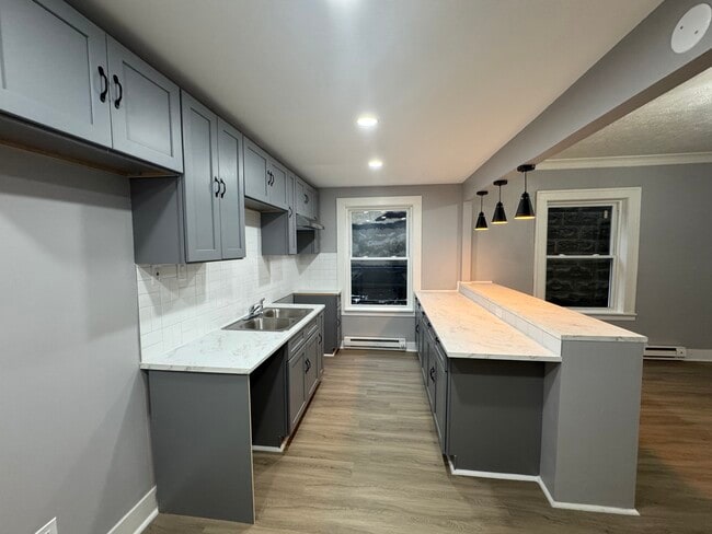 Stylish gray cabinetry, marble-look counters, and updated lighting.