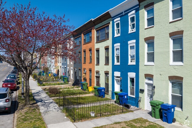 Colorful three-story townhomes in Remington have small yards with gates.