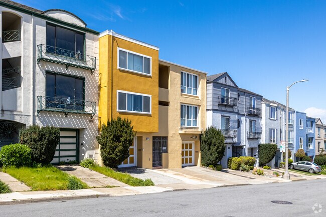 Yellow and bright, this multifamily home sits atop the sloping road in Anza Vista, San Francisco