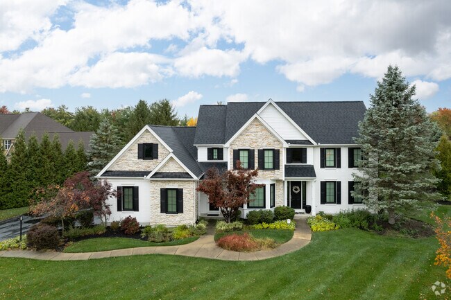 A large newer home with a small front porch and a large front yard in Stonebridge Farms.