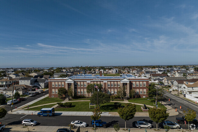 The front of the campus is flourishing with trees.