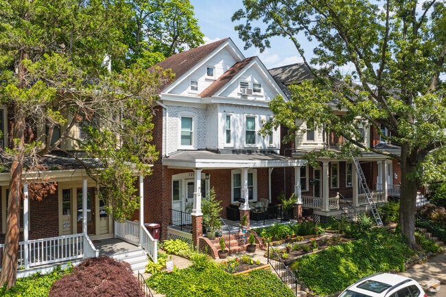 A classic Four Square home covered in shade with a large front porch in Triangle.