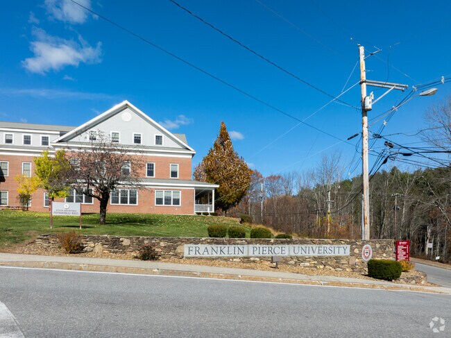 The entrance to Franklin Pierce University in Rindge, New Hampshire, with Petrocelli Hall standing under a clear blue autumn sky.