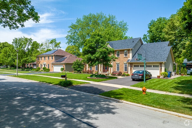 A row of brick colonial-style homes with well-manicured yards in the Brush Hill neighborhood.