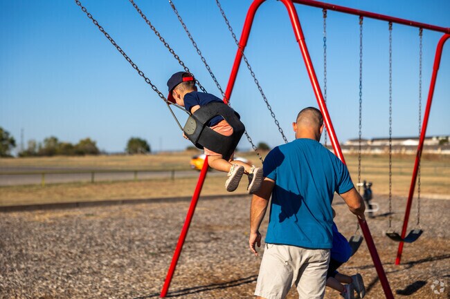 Kids love to play on the swingset at Eastside Park by Pecan Valley.
