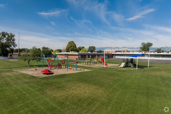 A colorful playground on a vibrant green field at Grant Elementary School.