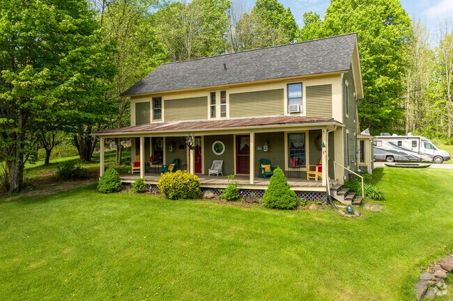 A colonial revival style home in Derby Center has green clapboard siding and a large front porch.