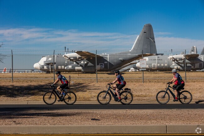 Cyclists pass by The Boneyard at Davis Monthan Air Force Base.