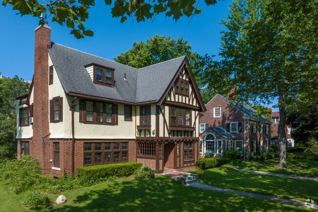 An Arts and Crafts home with Tudor details sits prominently on a Gold Coast corner lot.