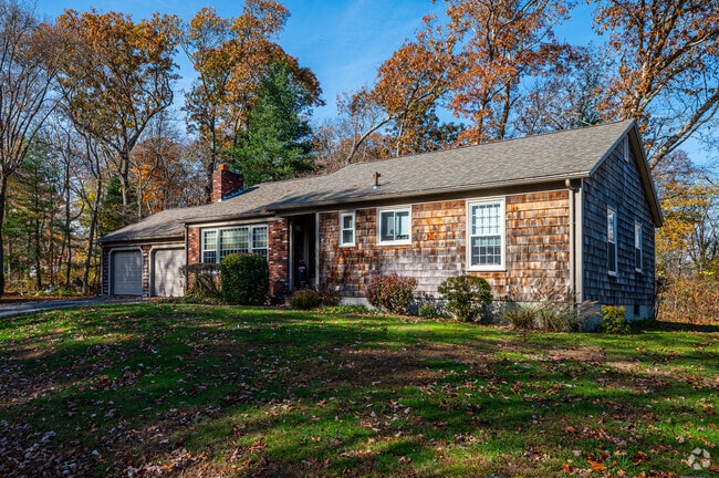 A moderate, single-story double-wide cape cod with clapboard siding.