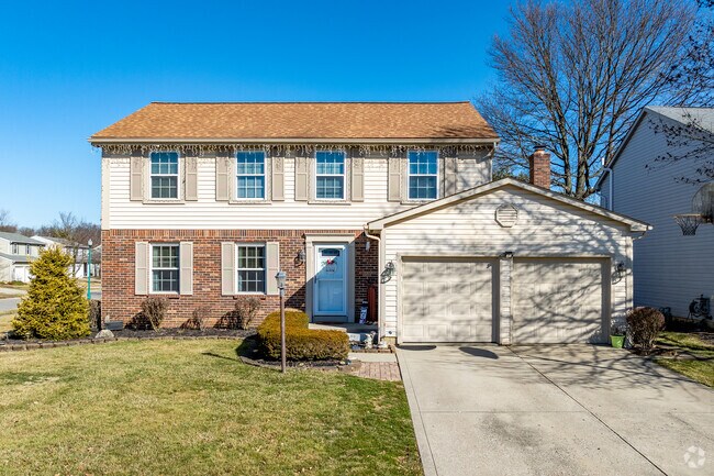 A contemporary colonial home in Woodside Green features an attached two-car garage.