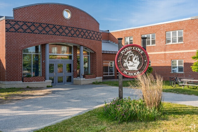 A beautiful wood crafted sign marks the entrance to the Pond Cove Elementary School.