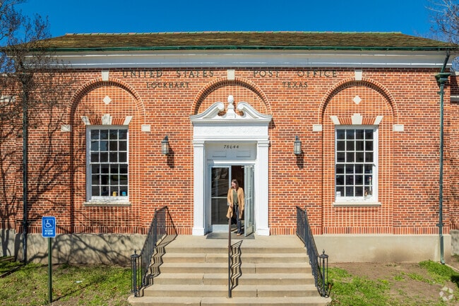 The historic Lockhart USPS building features classic brick architecture.