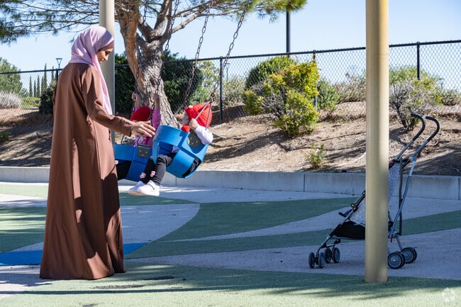 Familes enjoy the swingset and walking paths at Larry Lasater Park.