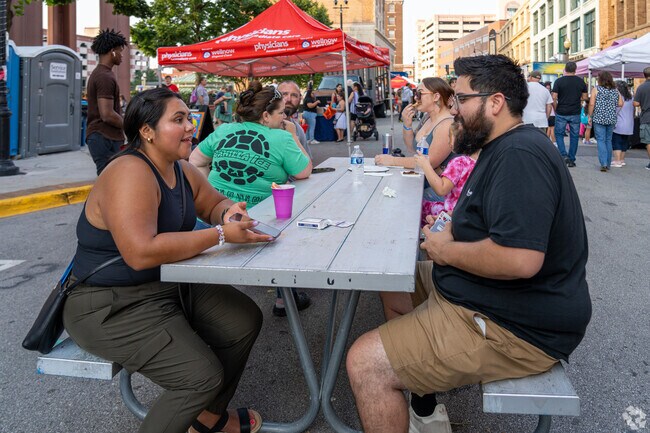 Friends play a game of cards at the Stolp Island Block Party in Downtown Aurora.