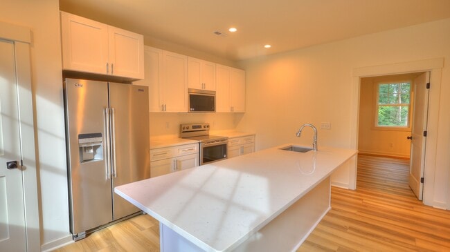 Untit A -Chef's kitchen with eat in island, quartz countertops and stainless appliances.
