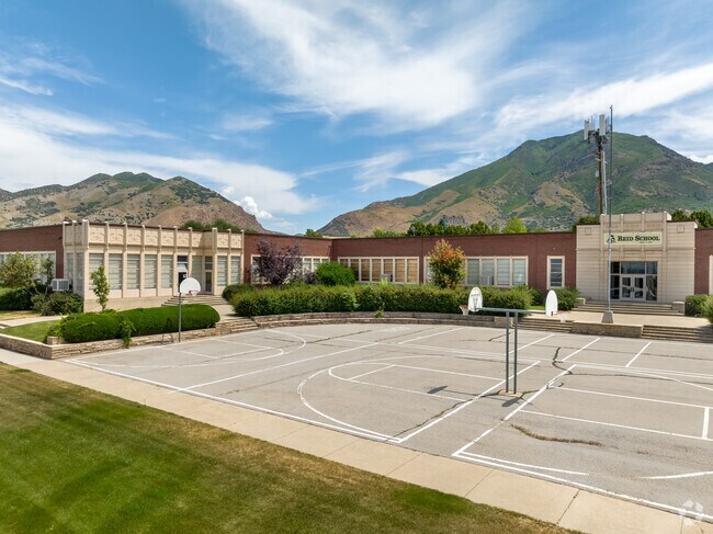 Students enjoy the basketball courts at Reid School with mountain views in the background.