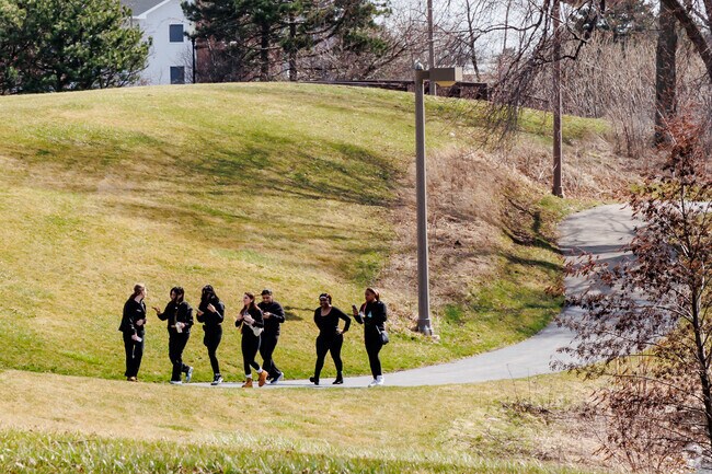 A group of friends walking up to take a group photo in a local park.