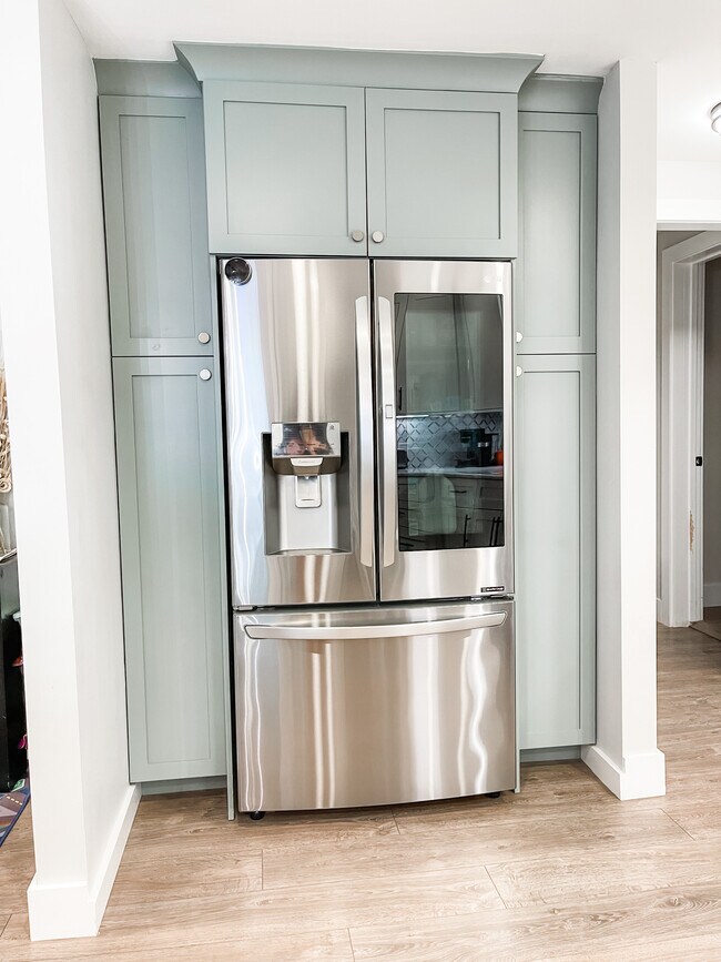 Custom cabinets surrounding full depth refrigerator with built in ice and water in the door.