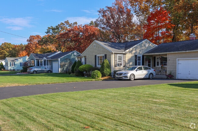 Sun-drenched homes on Burnett Road have front lawns that meet the street.