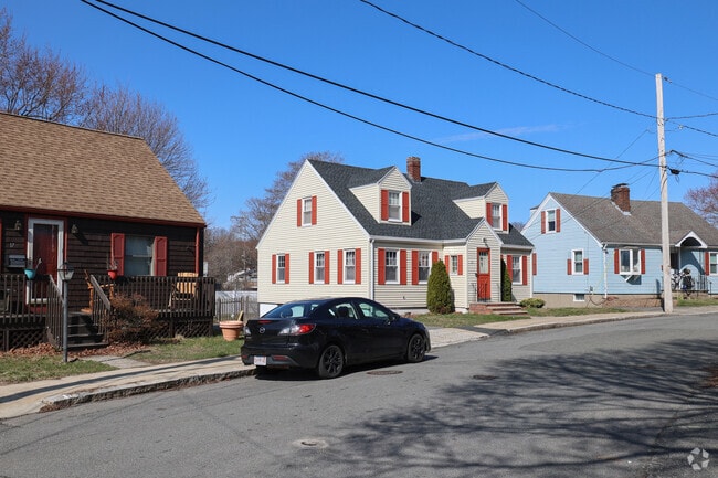 A mix of single-family and multi-family homes line the orderly streets of Castle Hill, framed by narrow sidewalks and shaded by a sparse canopy of established trees.