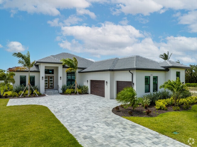 The Caloosahatchee River's shoreline is lined with sizable homes featuring multi-car garages.