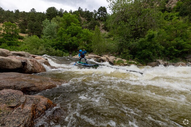 A white water paddle boarder takes a shot at one of Boulder Creek's Rapids.