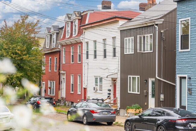 A unique array of row homes lines the streets of Polish Hill, some with updated siding.