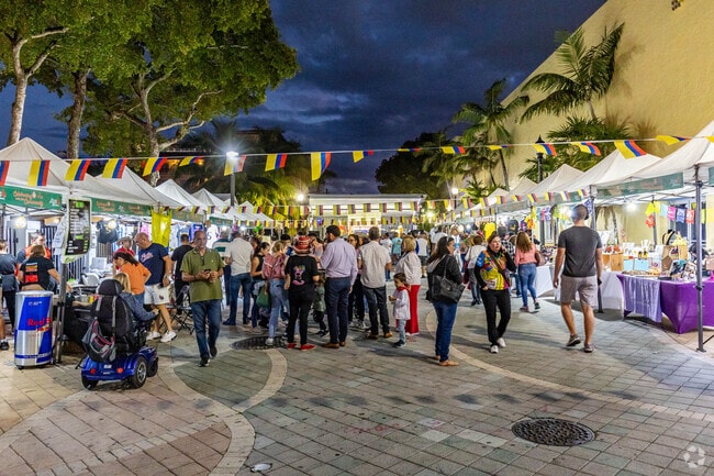 A family-friendly street fair lights up Calle Ocho in Little Havana at night.