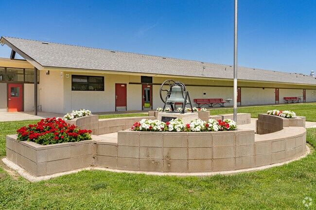 Tipton Elementary School features a flower garden and historic bell at its entrance.