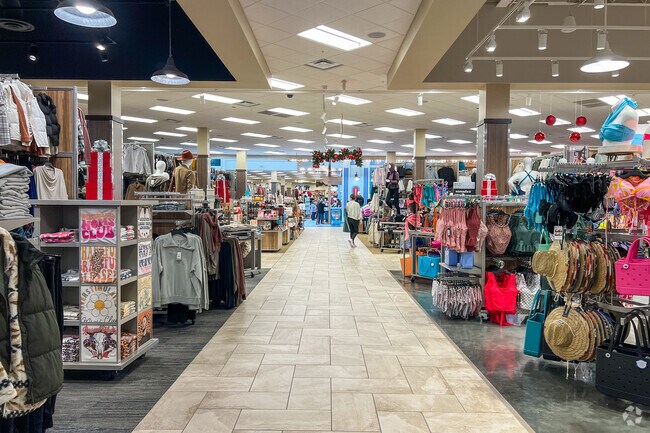 People buy sports apparel at Scheels near Harrison Park.