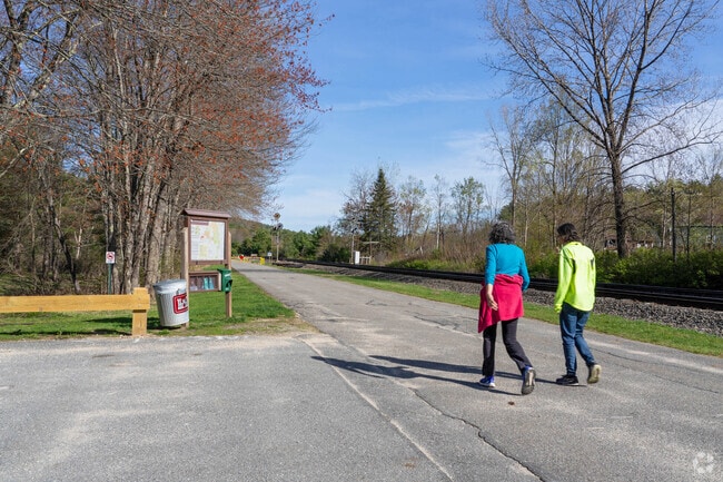 Folks walk along the Birch Hill Dam walking trail with scenic views of the Millers River in Royalston.