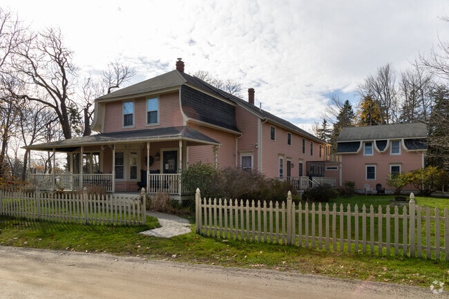 Classic New England homes with a guest house sits on a large lot in Long Island.