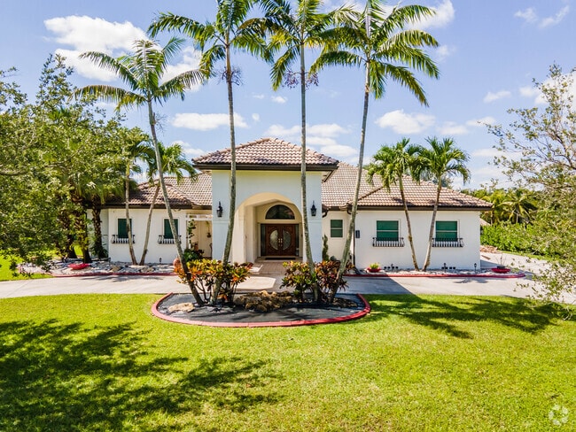 A large Spanish Revival home sits behind a manicured front lawn in Martha Bright Farms.