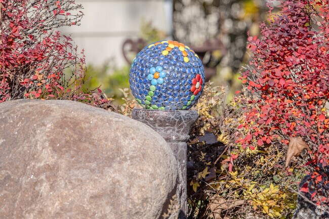 A mosaic garden sphere adds to the foliage in a Colonial Gardens lawn.