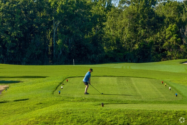 A Live Oak Reserve resident prepares to tee off at Twin Rivers Golf Club.