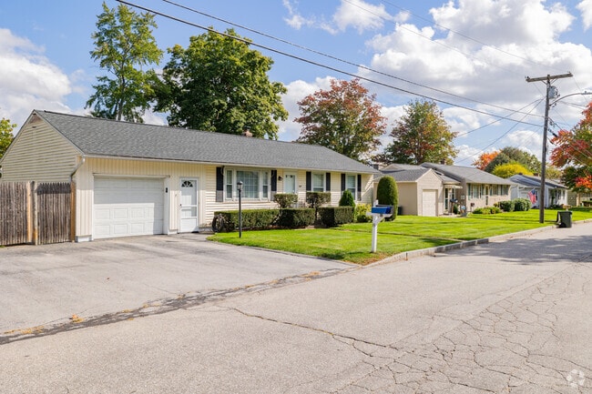 A row of residential homes in Goffe Falls presents a unified style, showcasing charming details.