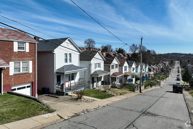Townhomes are connected with small driveways on a hilly neighborhood in Brookline, Pennsylvania.
