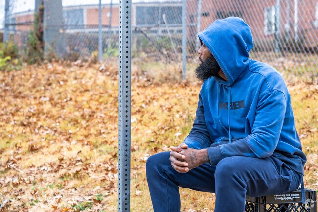A man sits and waits for his bus in the Riverview neighborhood.