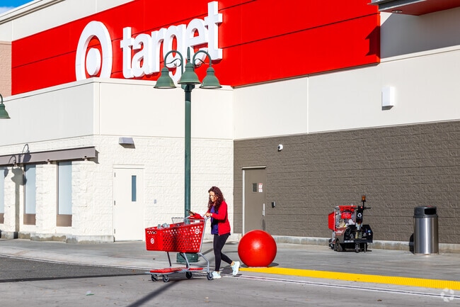 A woman stands in front of the red Target logo, feeling a sense of familiarity and comfort.